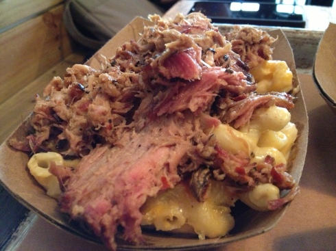 A generous side of mac and cheese arrives blanketed with succulent pulled pork. Add some hot sauce and rev the engines.